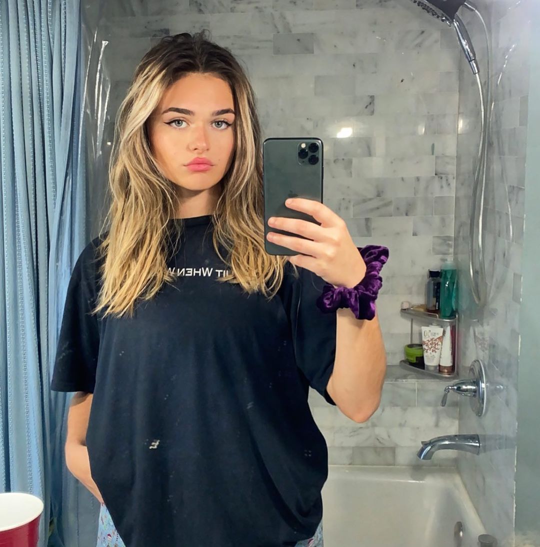 Megan Guthrie taking mirror selfie in black t-shirt