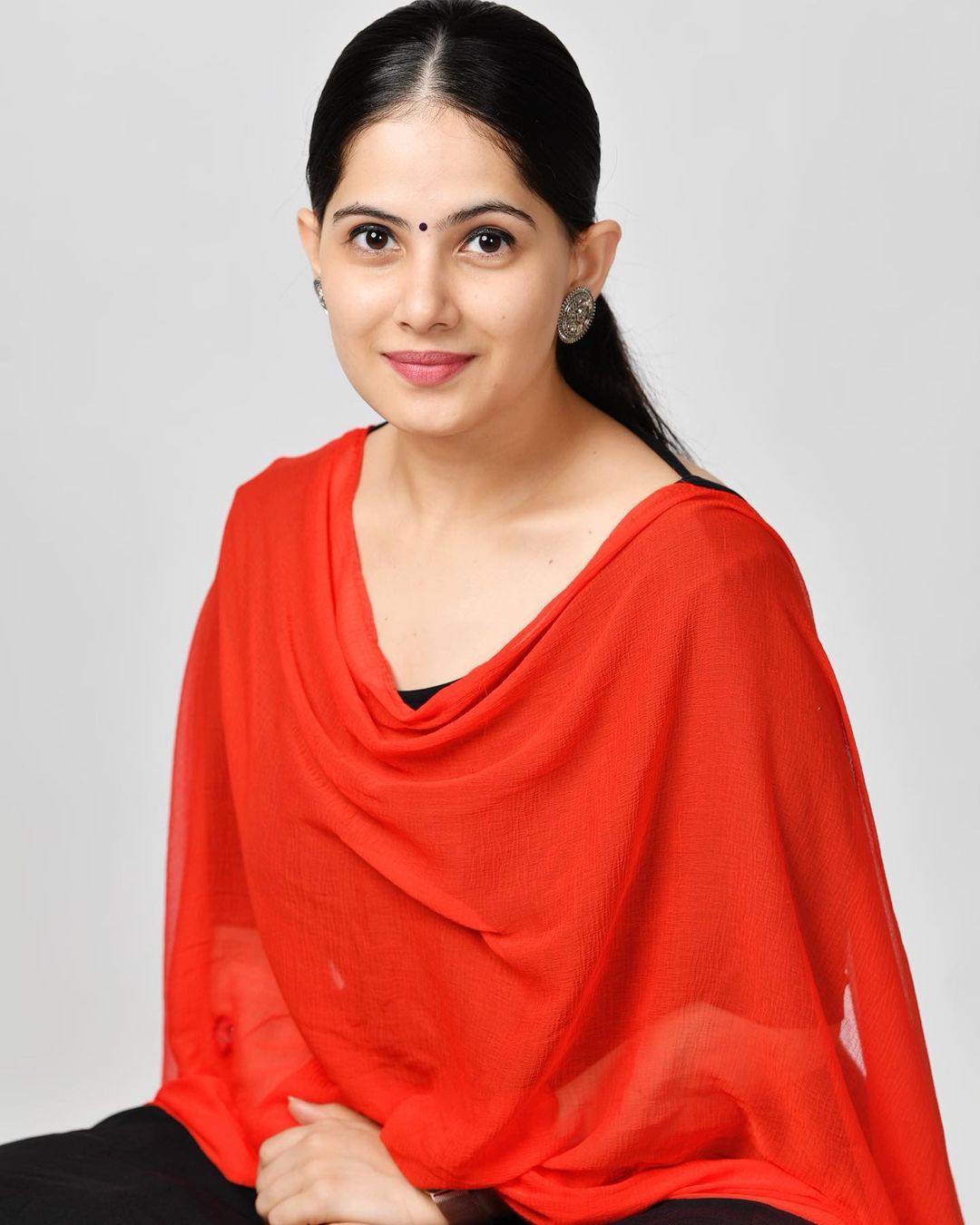 Jaya Kishori in black suit and red dupatta