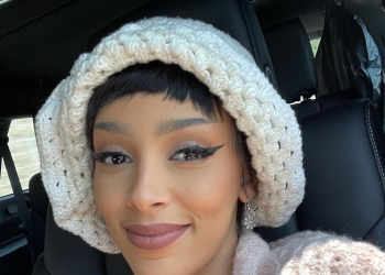 Doja Cat with a white cap on her head