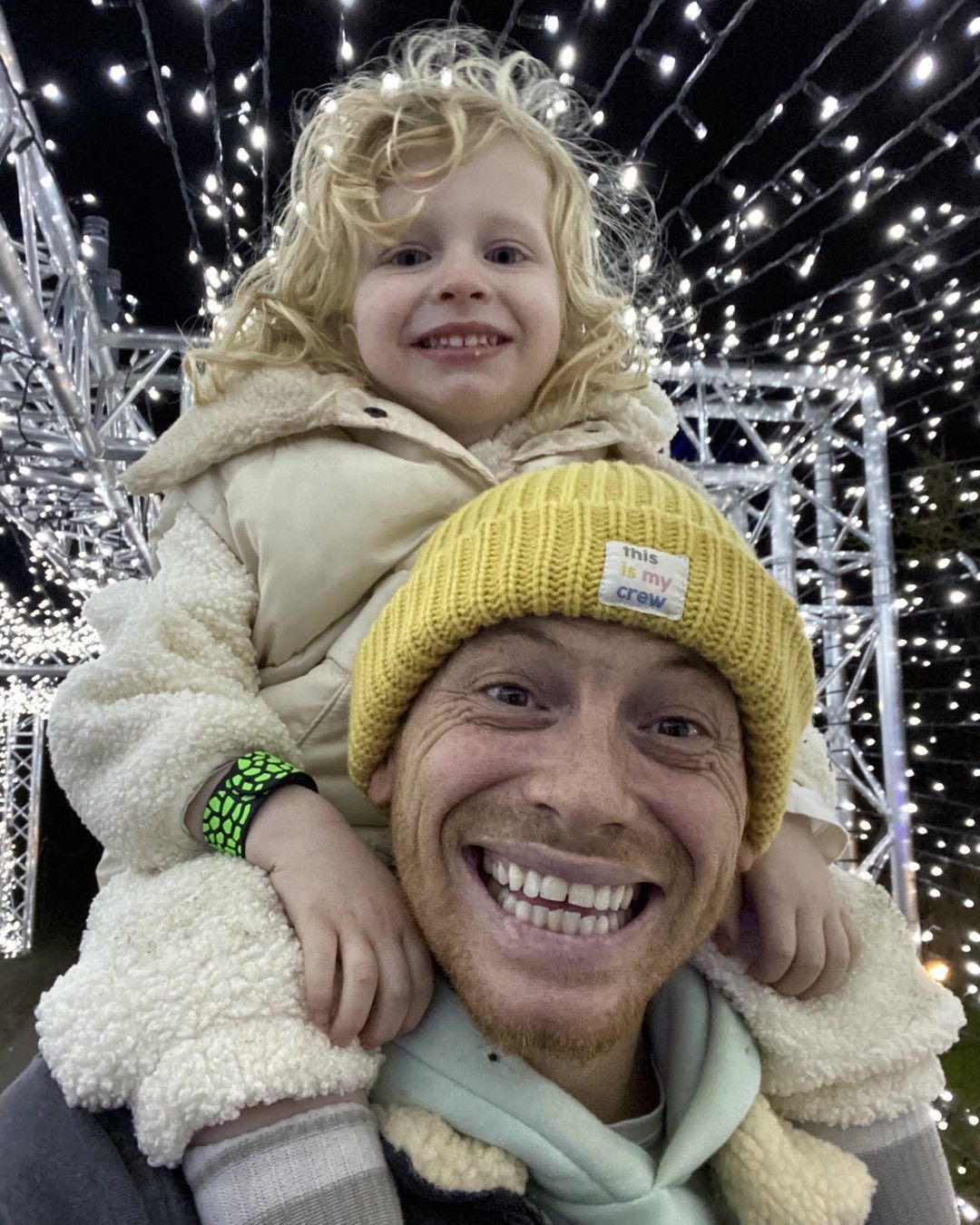 Joe Swash holding his child on his shoulders