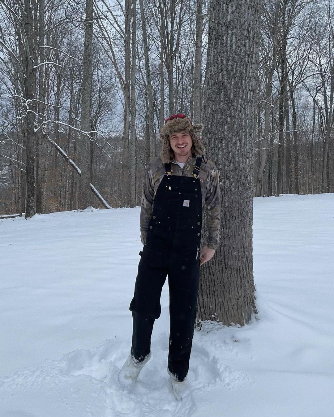 Morgan Wallen in duck bib overalls in snowy area