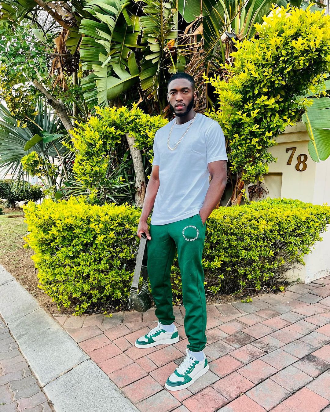 Daliwonga Motiwane in white t-shirt and green trouser