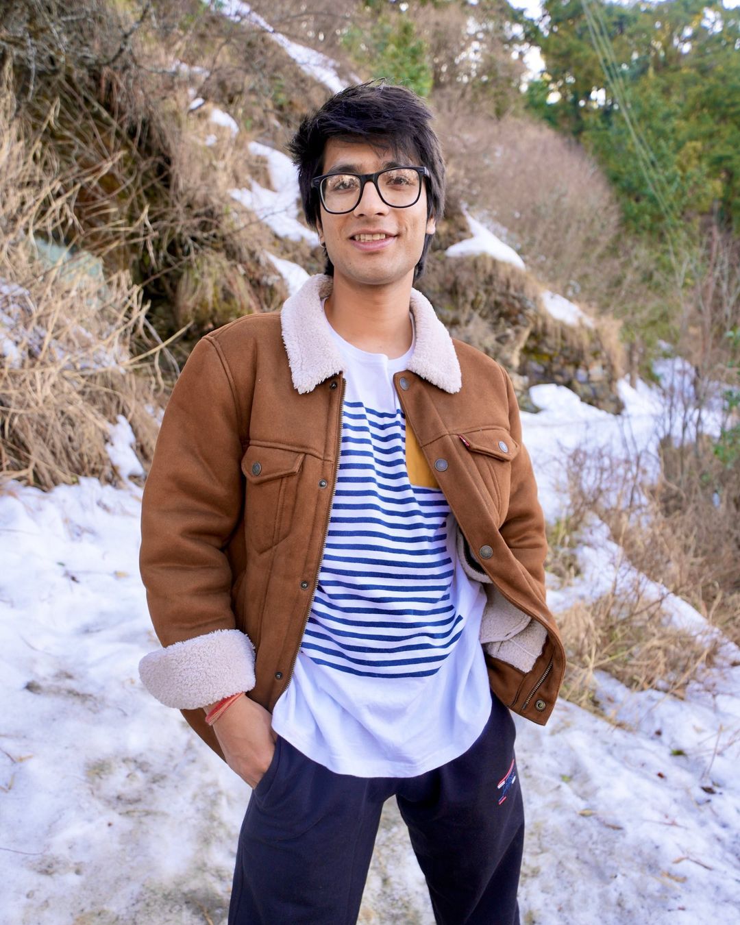 Sourav Joshi in brown jacket on a snowy mountain