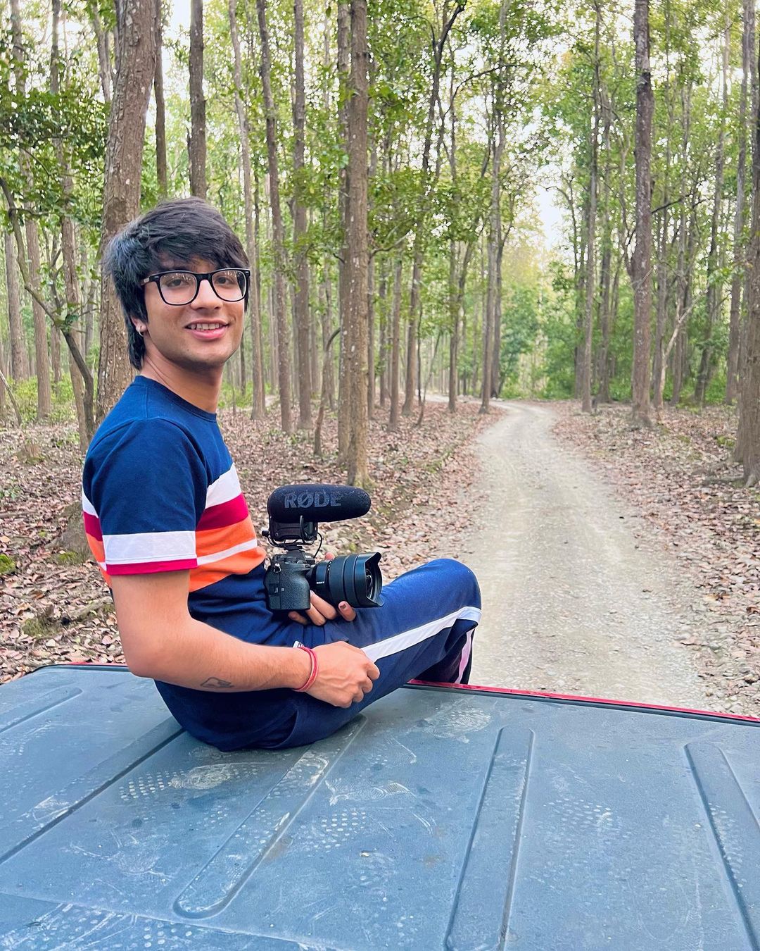 Sourav Joshi in blue attire holding a camera in hand