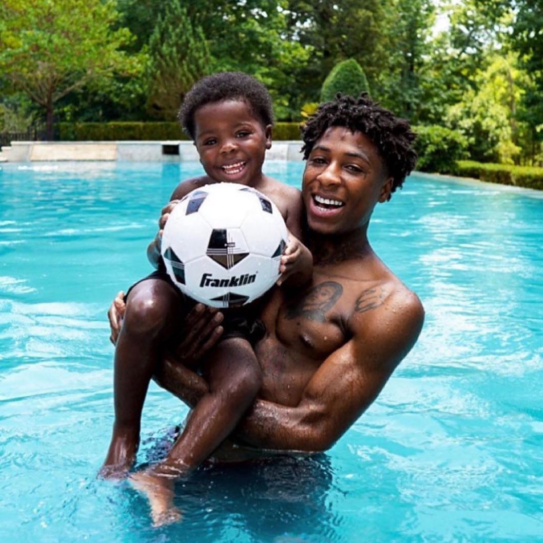 Kamiri Gaulden holding a football with his father in swimming pool