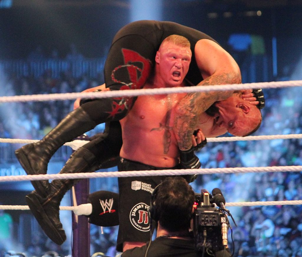 Duke LBrock Lesnar holding Undertaker on his shoulders in WWE Ring