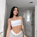 Emily Rinaudo in white cami top and grey shorts