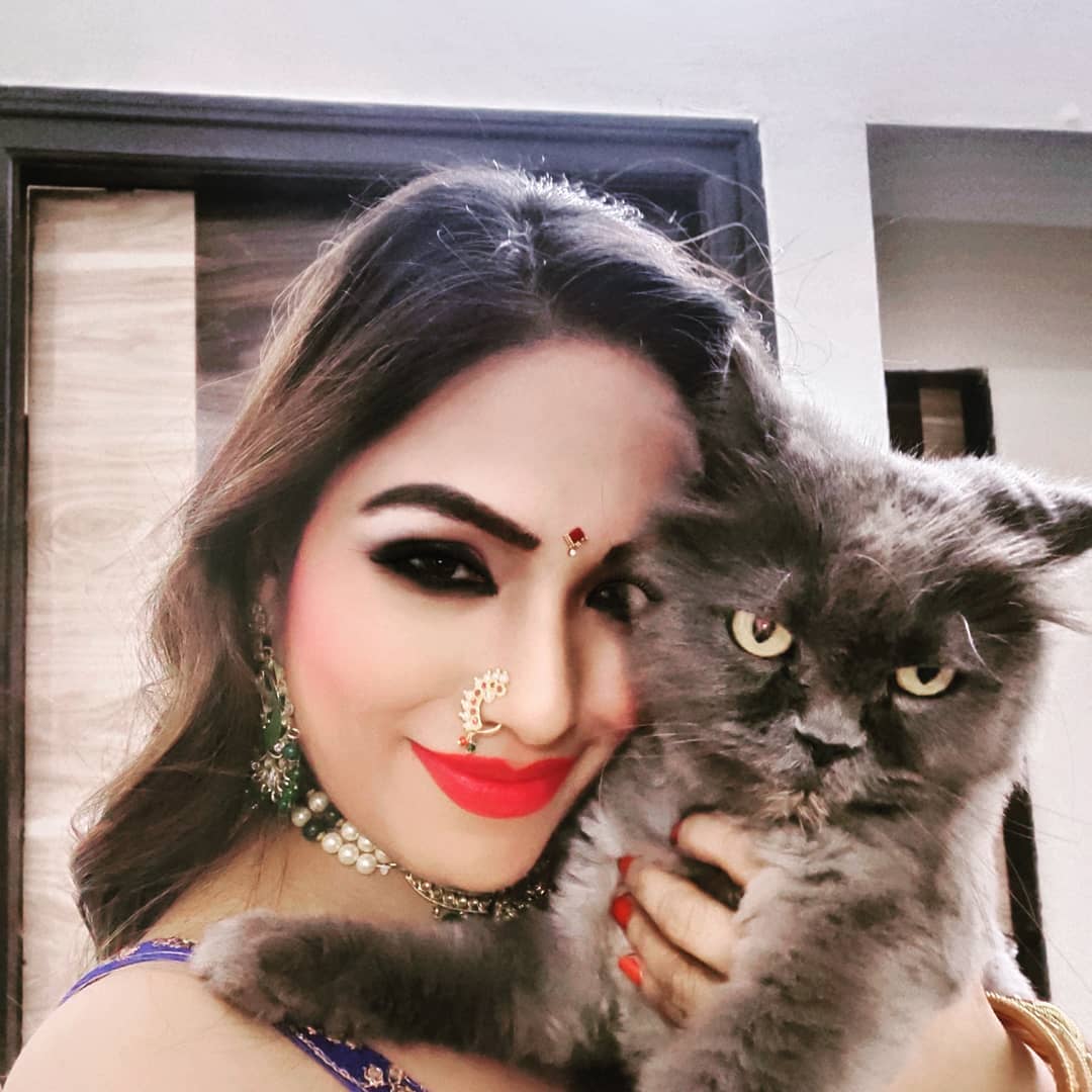 Zoya Rathore holding a black cat 