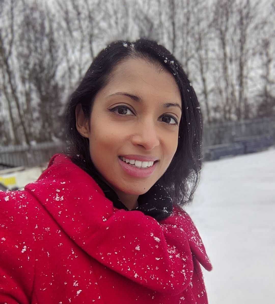 Luxmy Gopal in red coat enjoying snow