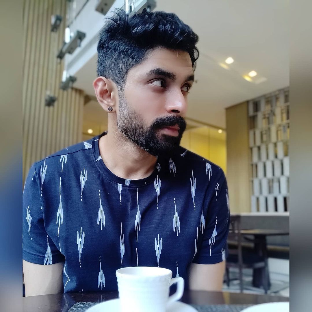 Abhishek Iyer in blue t-shirt drinking coffee