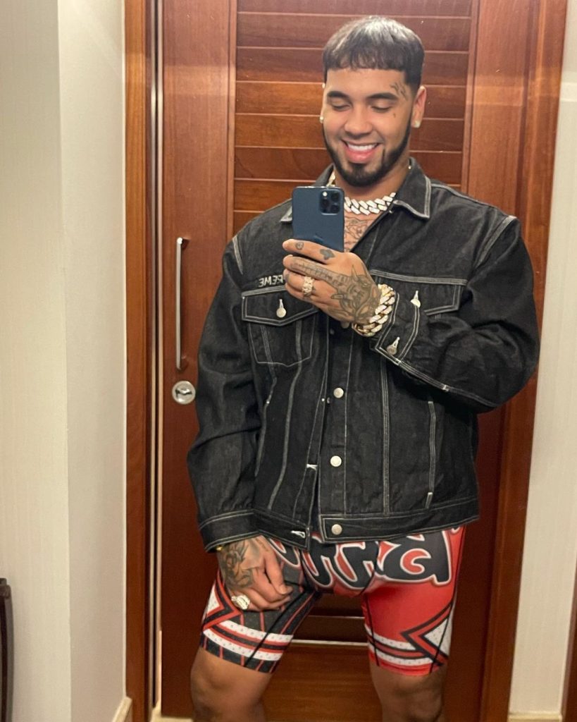 Anuel AA in black jacket and printed red shorts