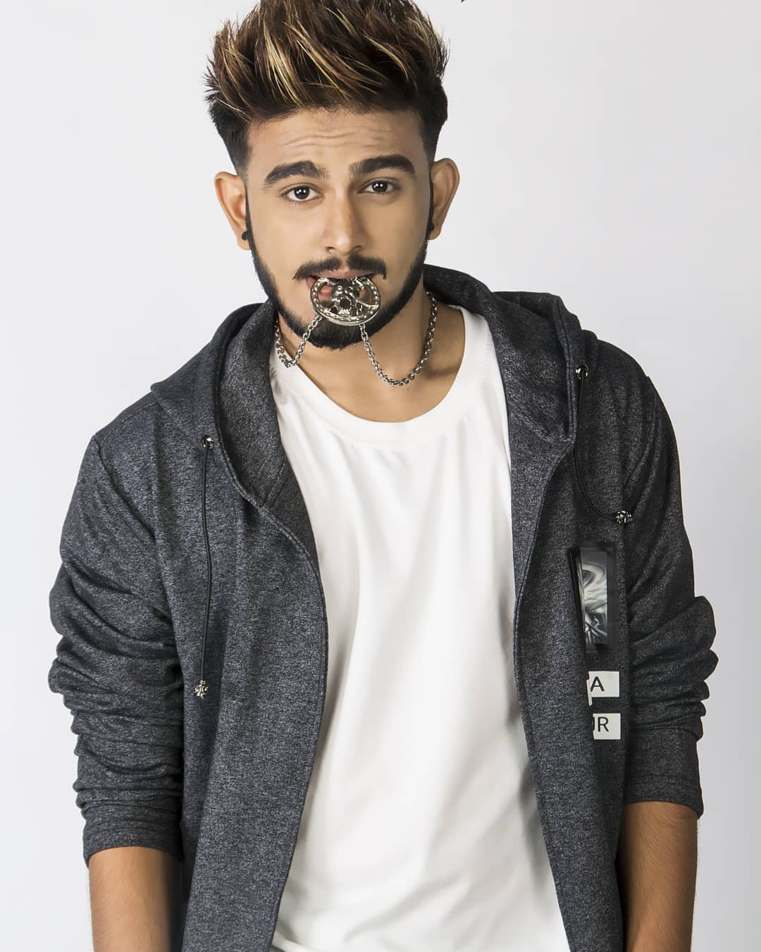 Shubham Deorukhar holding a neck locket in his mouth