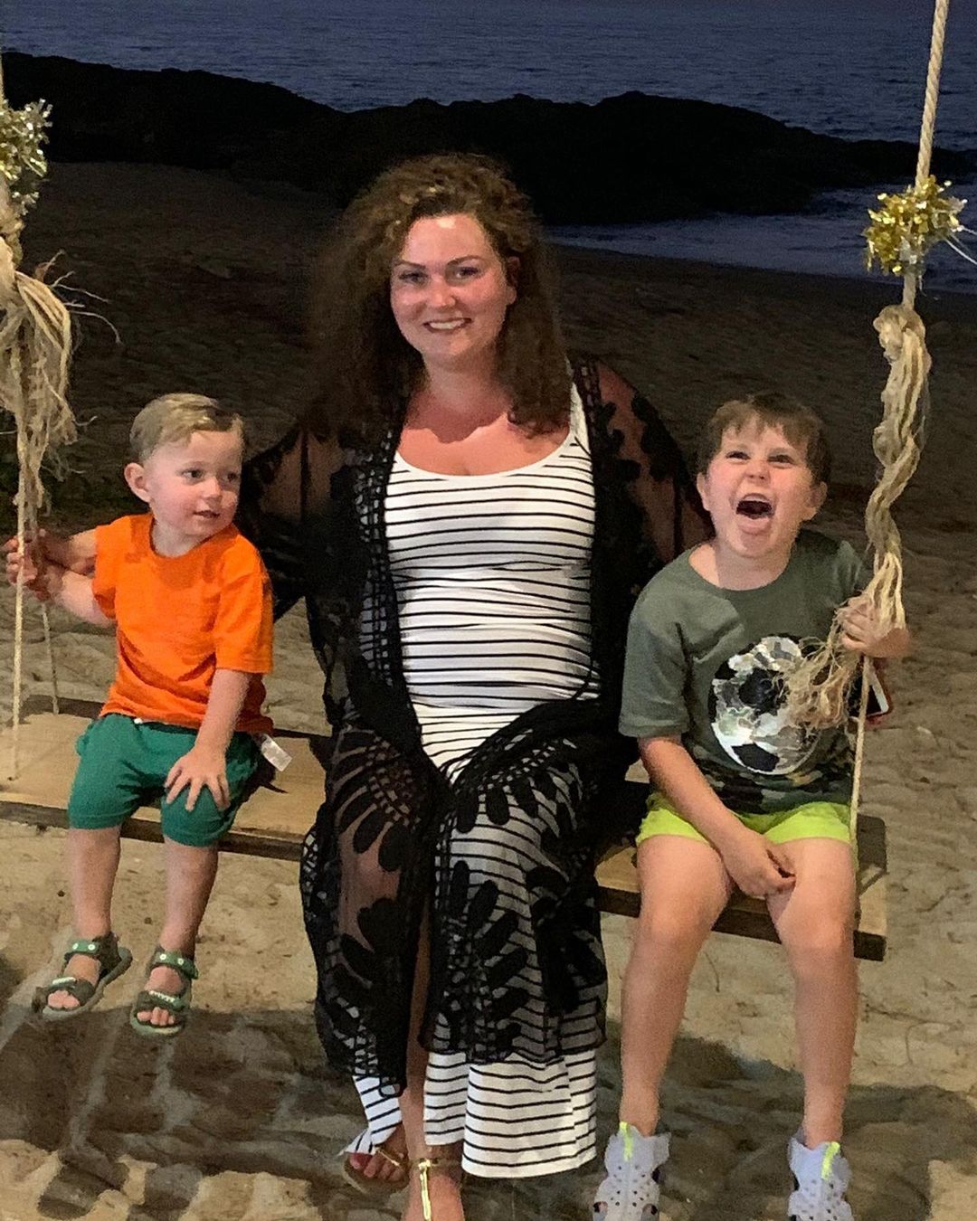 Dagmara Malczewska with sons on a swing in beach area