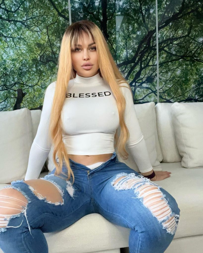 Andrea Abeli in white full sleeve top and ripped blue jeans