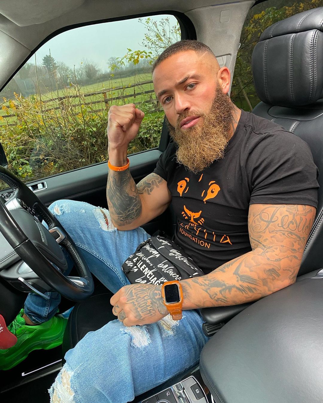 Ashley Cain in black t-shirt and blue jeans in a car