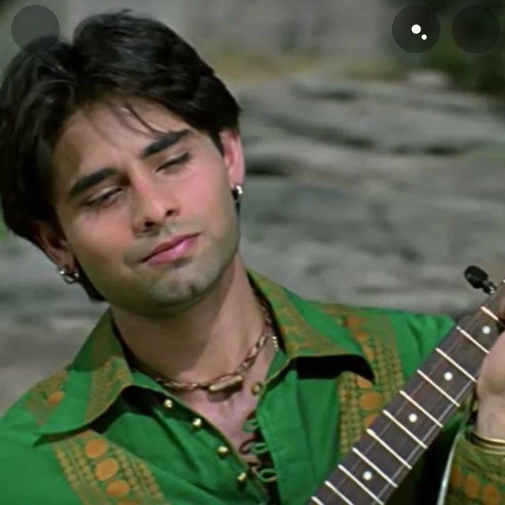 Nakul Kapoor in green dress playing a guitar