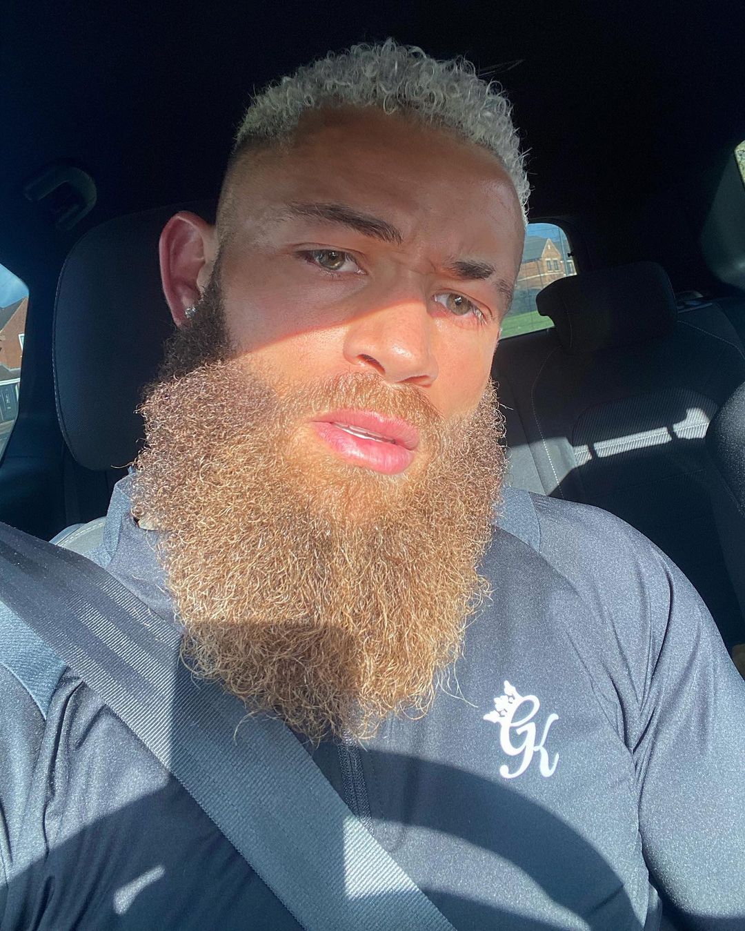 Ashley Cain in beard look sitting in a car