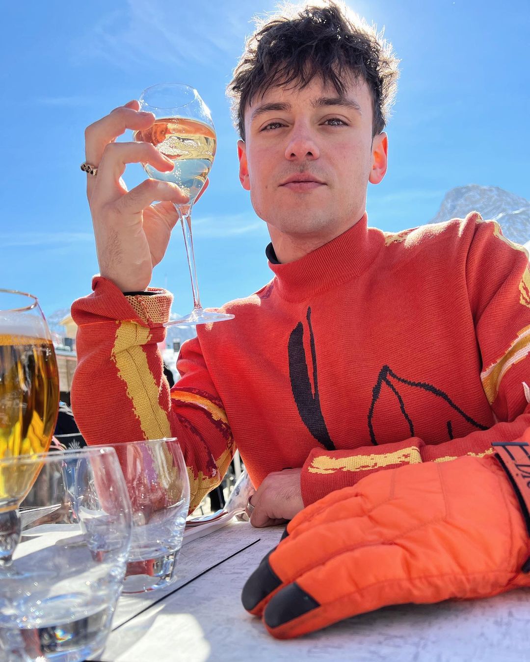 Tom Daley holding a glass of drink in hand