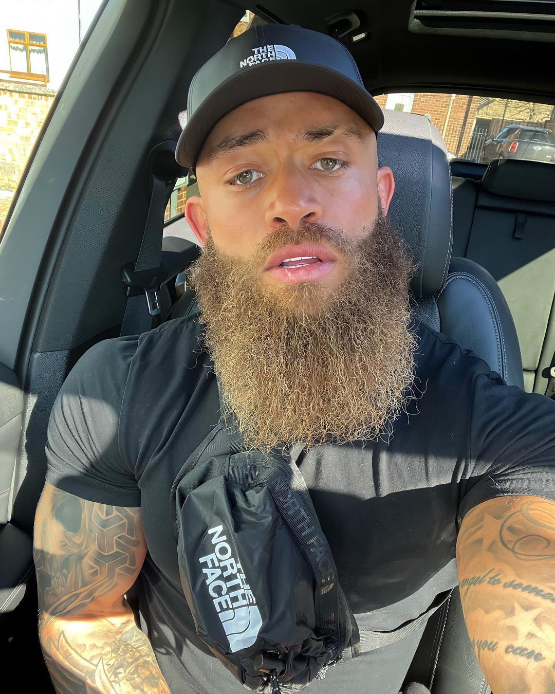 Ashley Cain sitting in his car in black t-shirt and cap